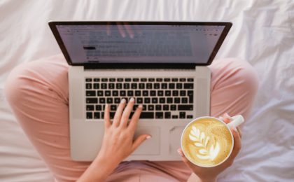 Woman enjoying cappuccino while on the MacBook Pro