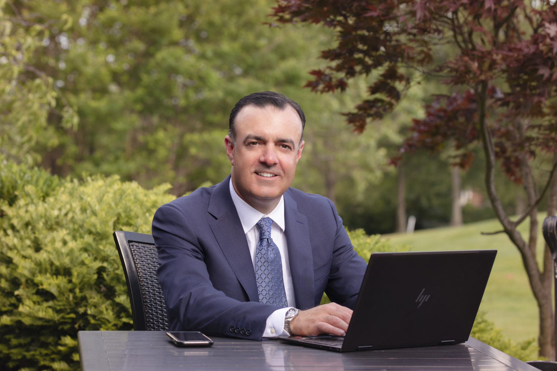 Business owner sitting outside with laptop computer.