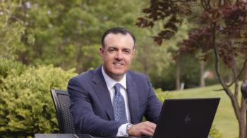 Business owner sitting outside with laptop computer.
