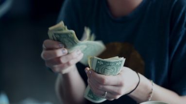 Person counting dollar bills