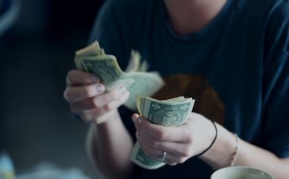 Person counting dollar bills