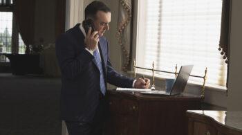 Branding photography image of a man taking notes while on the phone. Branding photography photographs makes it easier to attract your ideal client.