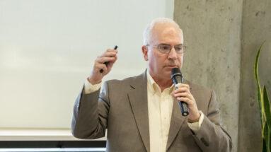 Speaker holding a microphone talking to his audience.