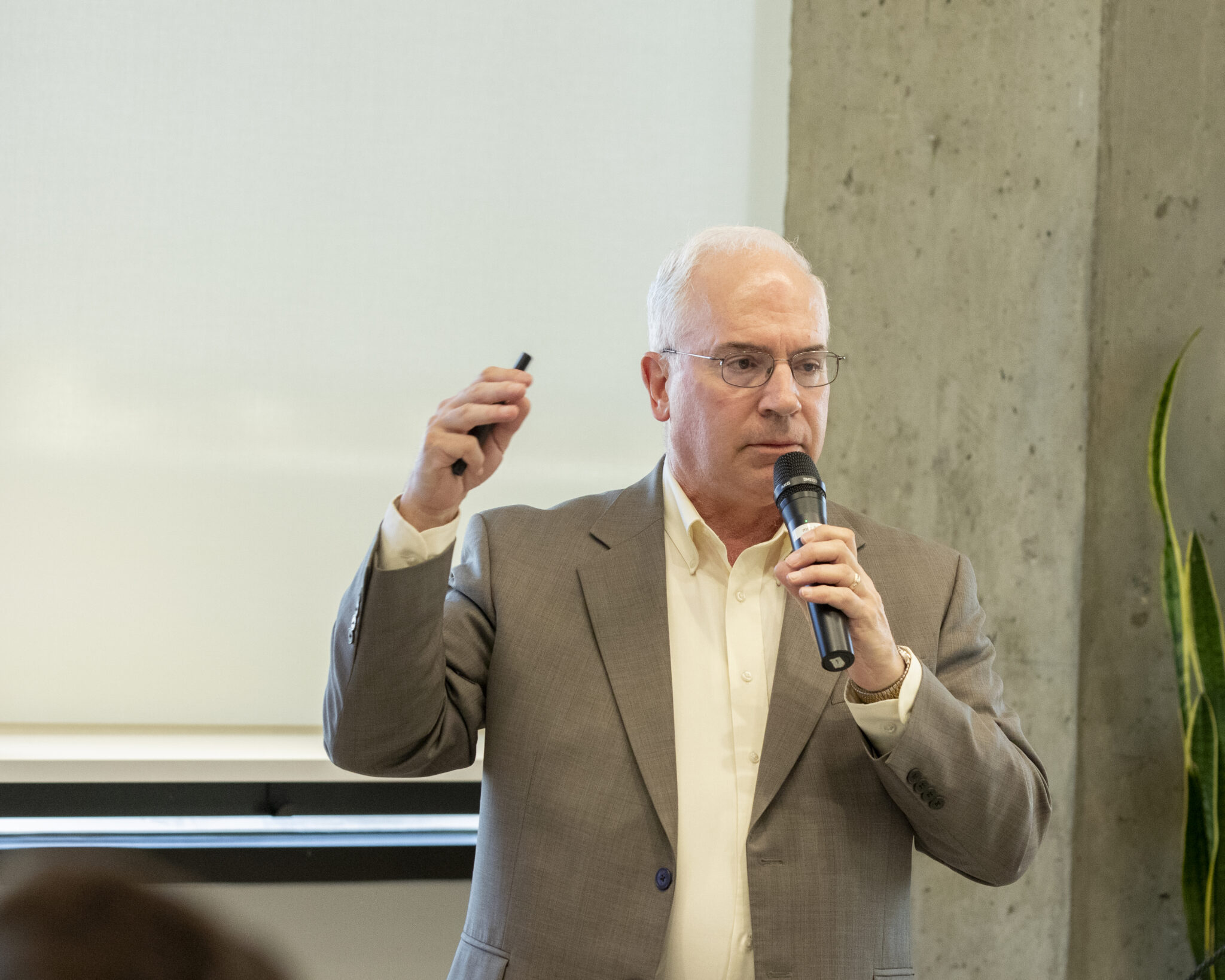Speaker holding a microphone talking to his audience.